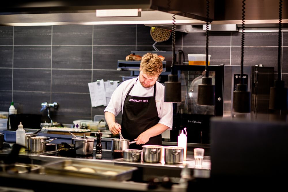 Level 2 Food Safety for Catering. Image of a chef preparing food in a commercial kitchen.