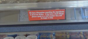 Red sign to remind customers to tell staff if they have food allergies.